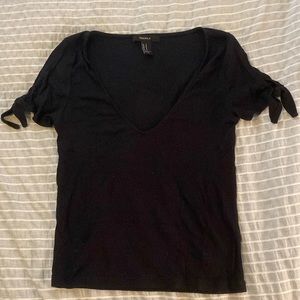 A black shirt with ties on the sleeves. Size M